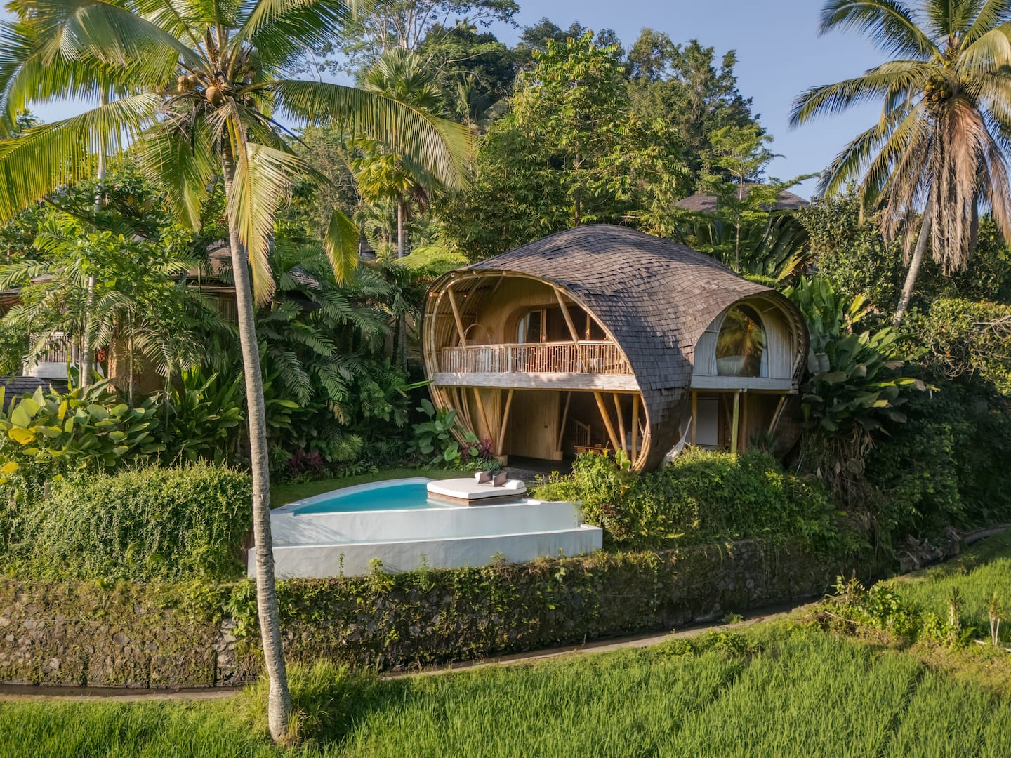 Curving bamboo architecture and a private turquoise pool at Eco Six Bali